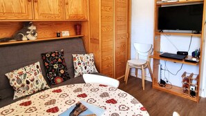 A cozy bedroom with a bed, wooden wardrobe, shelves, and a TV. - 2-Room Apt 4 People, South Balcony, Parking (Valloire)