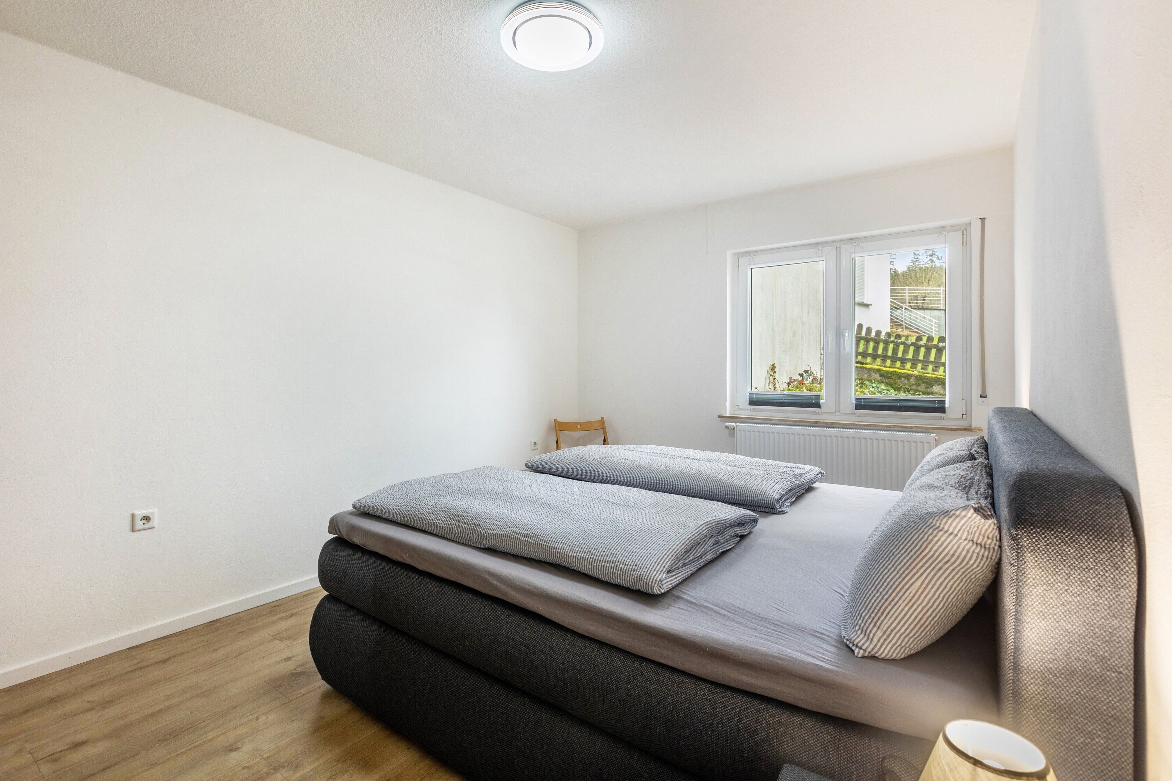 Une chambre à coucher avec un lit, une fenêtre et un radiateur.