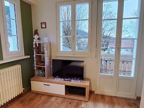 Une pièce comprenant un meuble de rangement en bois, un téléviseur à écran plat et un radiateur.