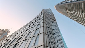 Un edificio alto y moderno con fachada de diseño enrejado y ventanas amplias.