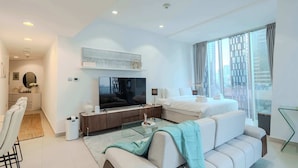 Una habitación de hotel moderna con una cama grande, un sofá, un televisor y un área de comedor.