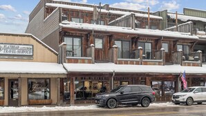 Un bâtiment sur lequel on peut voir une enseigne indiquant « Flathead Travel Service » et un salon de coiffure.