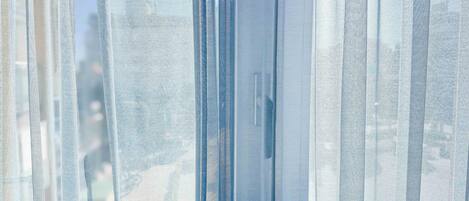 A close-up of sheer, textured curtains with a subtle pattern.