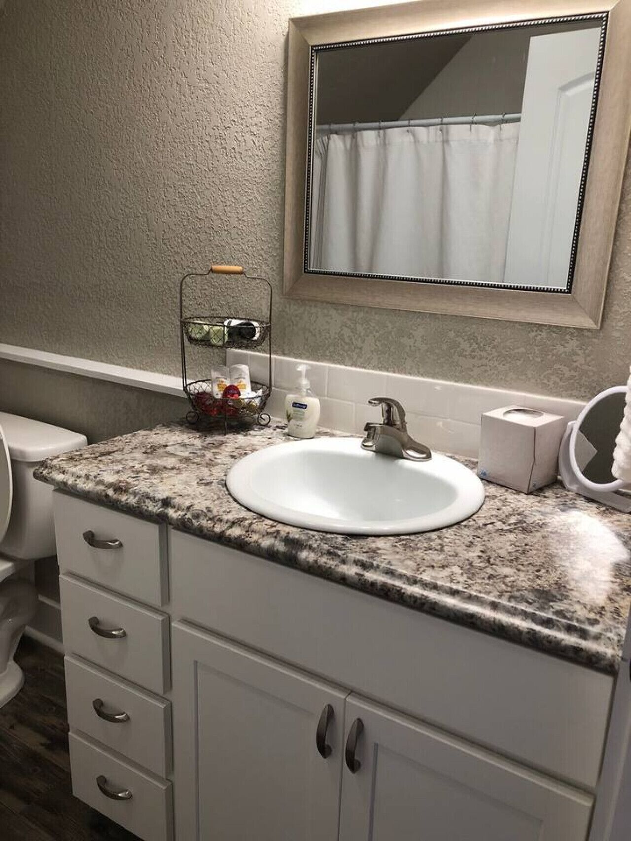 A bathroom with a white sink, a mirror, and a towel rack.