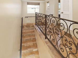 A staircase with a decorative metal railing and a window at the top. - Steps to the Sand in South Mission Beach 4BR Ocean Views Sleeps 10 (San Diego)