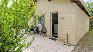 A small building with a door, two chairs outside, and a sign reading 'La Taverna.'