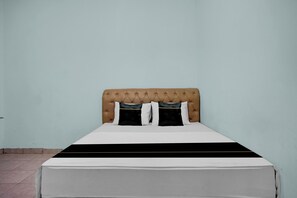 A bed with a tufted headboard, two black and white pillows, and a white and black bedspread. - Hotel O near Universitas Medan Area (Medan)
