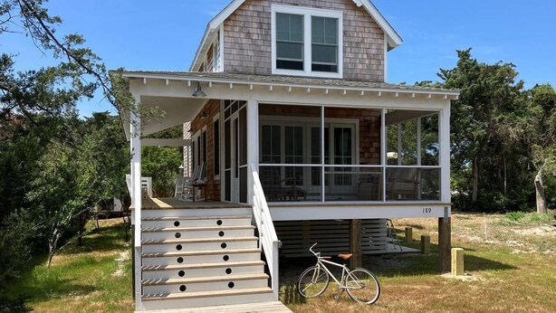 A two-story house with a covered porch and a staircase leading to the upper level. - Away - Ocracoke Island (Ocracoke)