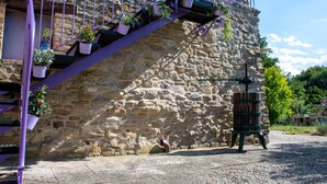 Un bâtiment en pierre avec un escalier et des plantes en pot.