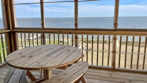 A wooden deck with a table and benches overlooking a beach. - Sundance - Ocracoke Island (Ocracoke)