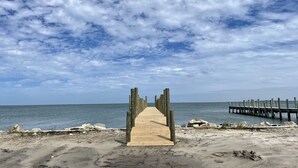 A wooden pier leading to a beach with a clear sky and calm sea. - Sundance - Ocracoke Island (Ocracoke)