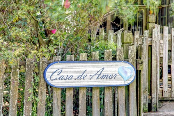 Puisesta kyltistä löytyy teksti ”Casa de Amor” ja sydämen muotoinen symboli.