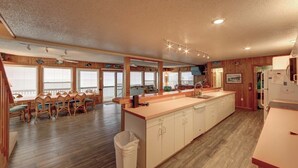 Una cocina amplia con armarios de madera, una isla grande y un comedor con sillas de madera.