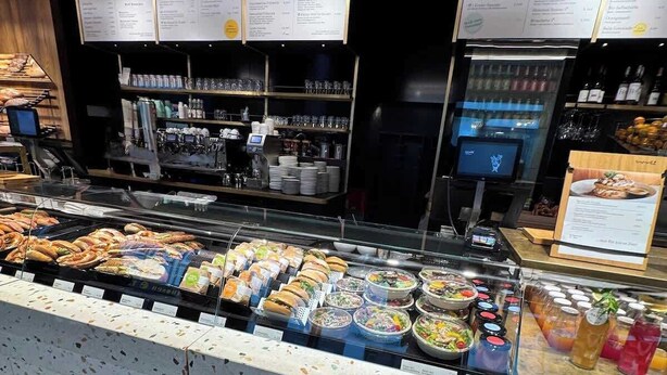 Ein Bereich mit Buffet, verschiedenen Speisen, einer Kaffeestation und einer Speisekarte.