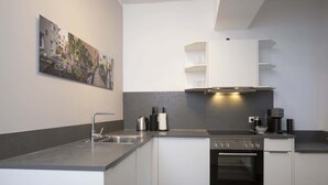 A modern kitchen with a built-in oven, a sink, and a coffee maker. - Luxury Suite "Augusta Vindelicum" | Rathausplatz Augsburg | A/C | Elevator (Augsburg)