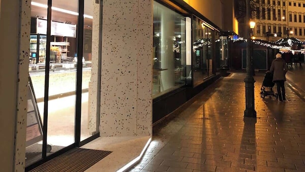 A building with a modern facade, large glass windows, and a neon sign. - Luxury Suite "Augusta Vindelicum" | Rathausplatz Augsburg | A/C | Elevator (Augsburg)