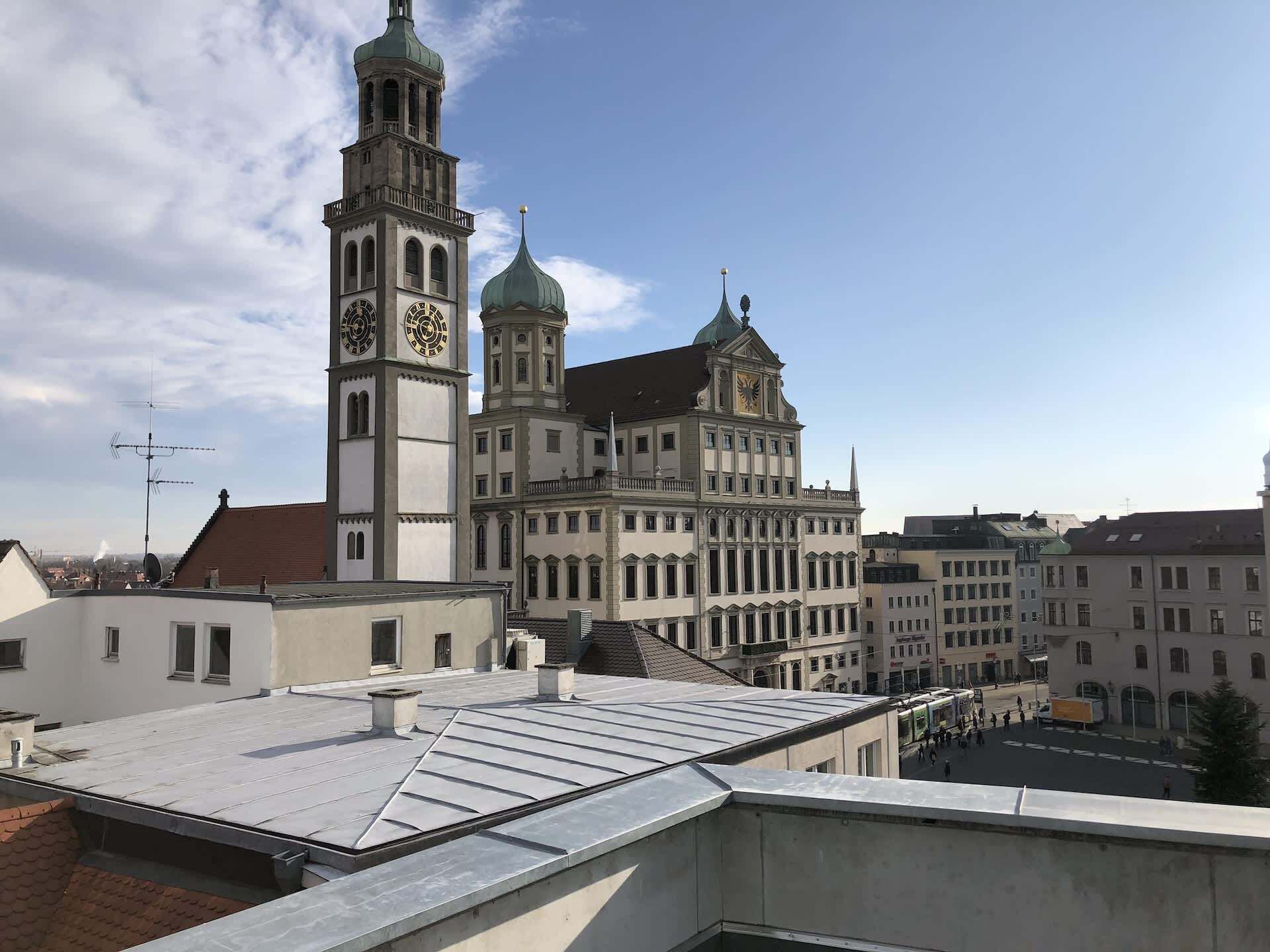 A historic building with a clock tower and a dome, surrounded by other buildings.