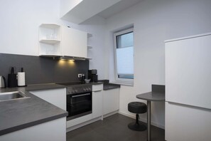 Een koelkast, een oven, een kookplaat, een vaatwasser