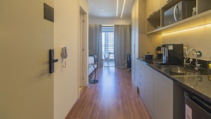 A modern hotel room with a kitchen area, a dining area, and a view of a cityscape. - Near Allianz Parque Sp-p1803b (São Paulo)