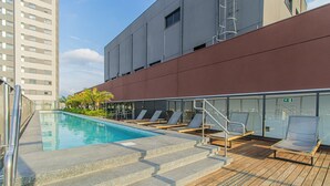 A rooftop pool area with a clear view of the city skyline, a set of stairs leading to the pool, and several lounge chairs. - Comfort Near Allianz Parque Sp-p1804b (São Paulo)