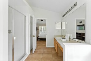 A modern bathroom with a shower, a sink, and a mirror. - 4BR Lake Berkley Villa, Heated Pool (Kissimmee)