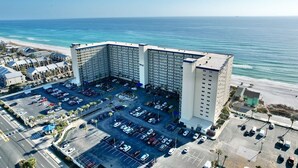 A large hotel with a central parking lot and a view of the ocean. - AWESOME OCTOBER DEAL- ANY WEEK=1400 Total! 5star/Beachfront/FREE Beach Chairs! (Panama City Beach)