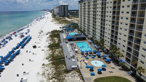 A beachfront hotel with multiple swimming pools, beach umbrellas, and a sandy beach. - AWESOME OCTOBER DEAL- ANY WEEK=1400 Total! 5star/Beachfront/FREE Beach Chairs! (Panama City Beach)