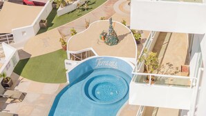 Luchtbeeld van een hotel met een zwembadgedeelte, genaamd 'Terrazas', omringd door groen en plantenpotten.