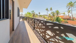 Un balcone dal design moderno, con pavimento in legno e ringhiera in metallo decorativa.