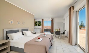 Ein Hotelzimmer mit zwei Betten, einem Essbereich und einem Balkon mit Blick.