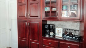 A kitchen with wooden cabinets, a coffee maker, and a coffee bar sign. - Quaint & Cozy Indiana Style (Shelbyville)