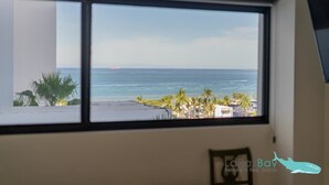 Una stanza con un'ampia finestra vista spiaggia e mare.