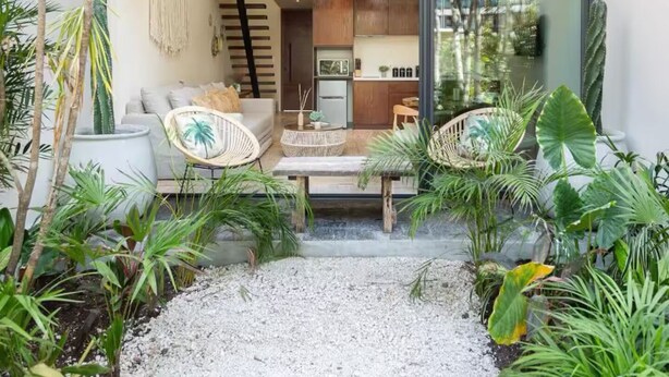 Een modern huis met een ruime woonkamer, een keuken en een balkon met planten.