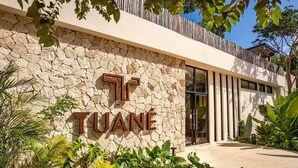 A stone facade with a large sign reading "TUANÉ". - Exquisitely Decorated 2 BD Retreat in Tulum (Tulum)