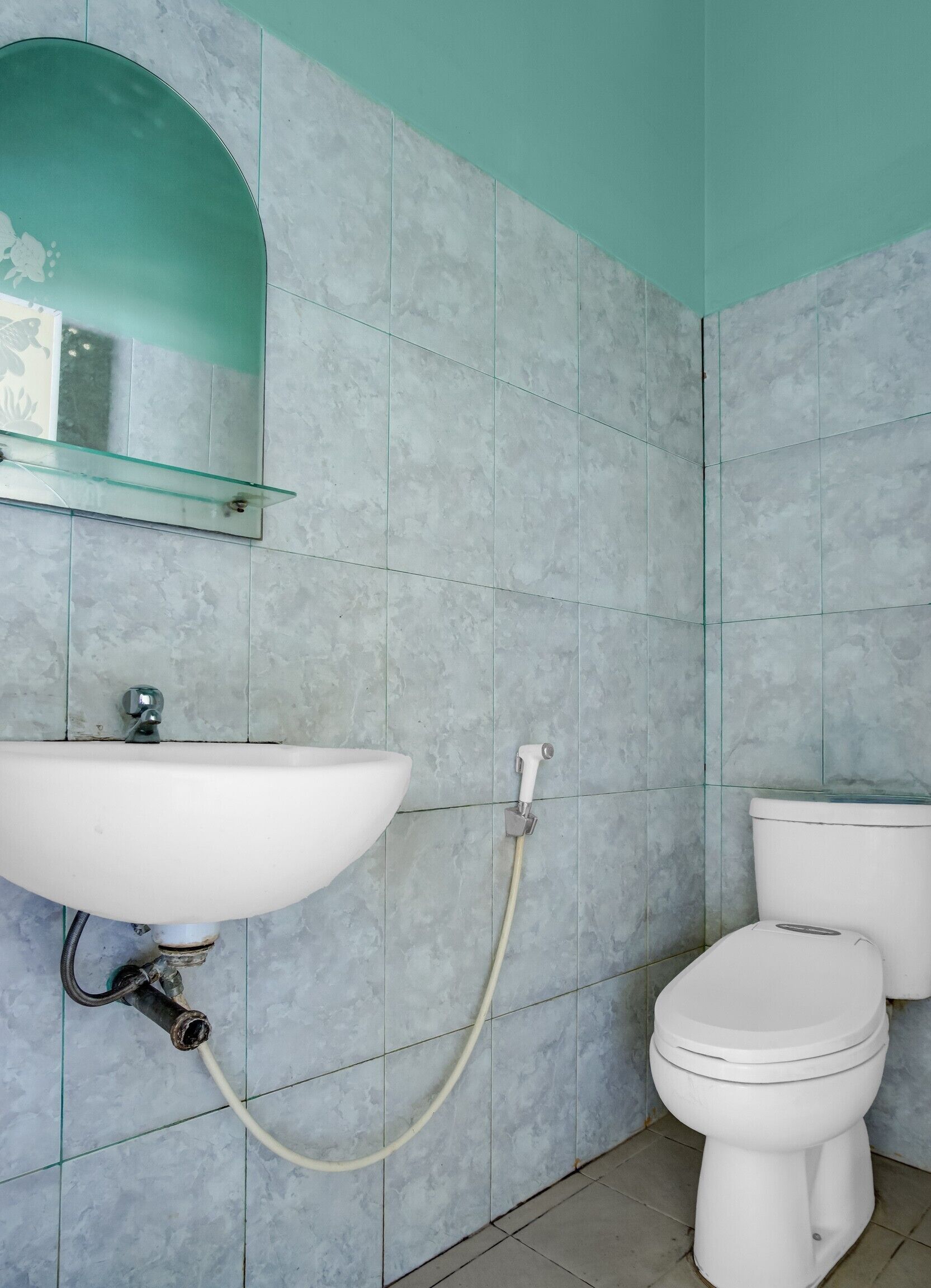 Une salle de bain avec un lavabo blanc, une cabine de douche en verre et des toilettes blanches.