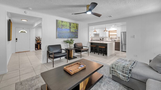 A modern living room with a dark coffee table, a grey sofa, and a large painting of a forest. - Peaceful Retreat Four Bedroom home in charming Shenandoah (Shenandoah)