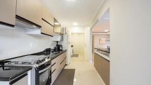 A modern kitchen with a stove, oven, microwave, and a refrigerator. - Apt w/ 3 BR & Grill 400m From the Beach Prs0101 (Itapema)
