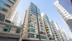 A high-rise building with multiple floors, large windows, and a modern architectural design. - Apt w/ 3 BR & Grill 400m From the Beach Prs0101 (Itapema)