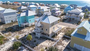 Una zona residenziale sulla costa, con diverse case a due piani, alcune dotate di balconi e qualcuna con scale esterne.