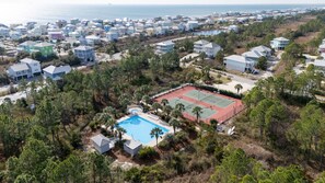 Vista aérea de um bairro residencial com casas, quadra de tênis e piscina.