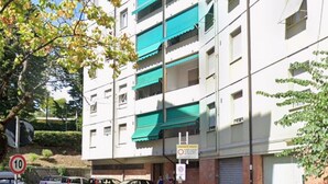 A multi-story building with balconies, a speed limit sign of 10, and a no parking sign.