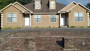 A two-story residential building with a symmetrical facade, a central entrance, and a small front porch. - 2-bedroom house in wonderful Demopolis with cool AC (Demopolis)