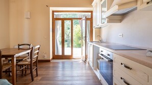 A kitchen with wooden cabinets, a dining table with chairs, and a sliding glass door leading to an outdoor area.