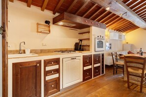 A kitchen with wooden cabinets, a gas stove, and a built-in oven. - Green Deluxe Casa De Fiori – Agriturismo with Experiences, Breakfast Included - Le Ceregne Bio (Pieve Santo Stefano)