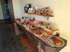 Una mesa de buffet con diversas opciones de comida, salsas y una estación de café.