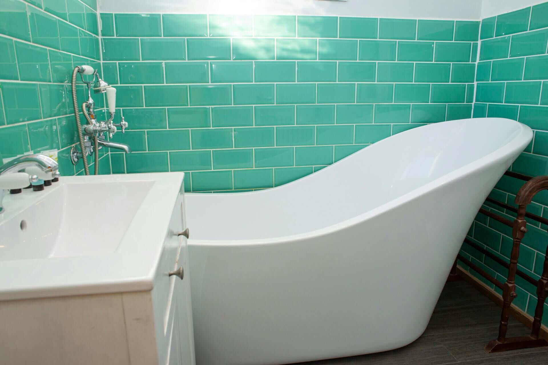 A bathroom with a freestanding bathtub, a sink, and a showerhead.