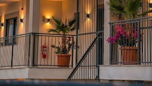 Un hôtel avec une enseigne indiquant « TopTepeHome » et un balcon orné de plantes en pot.