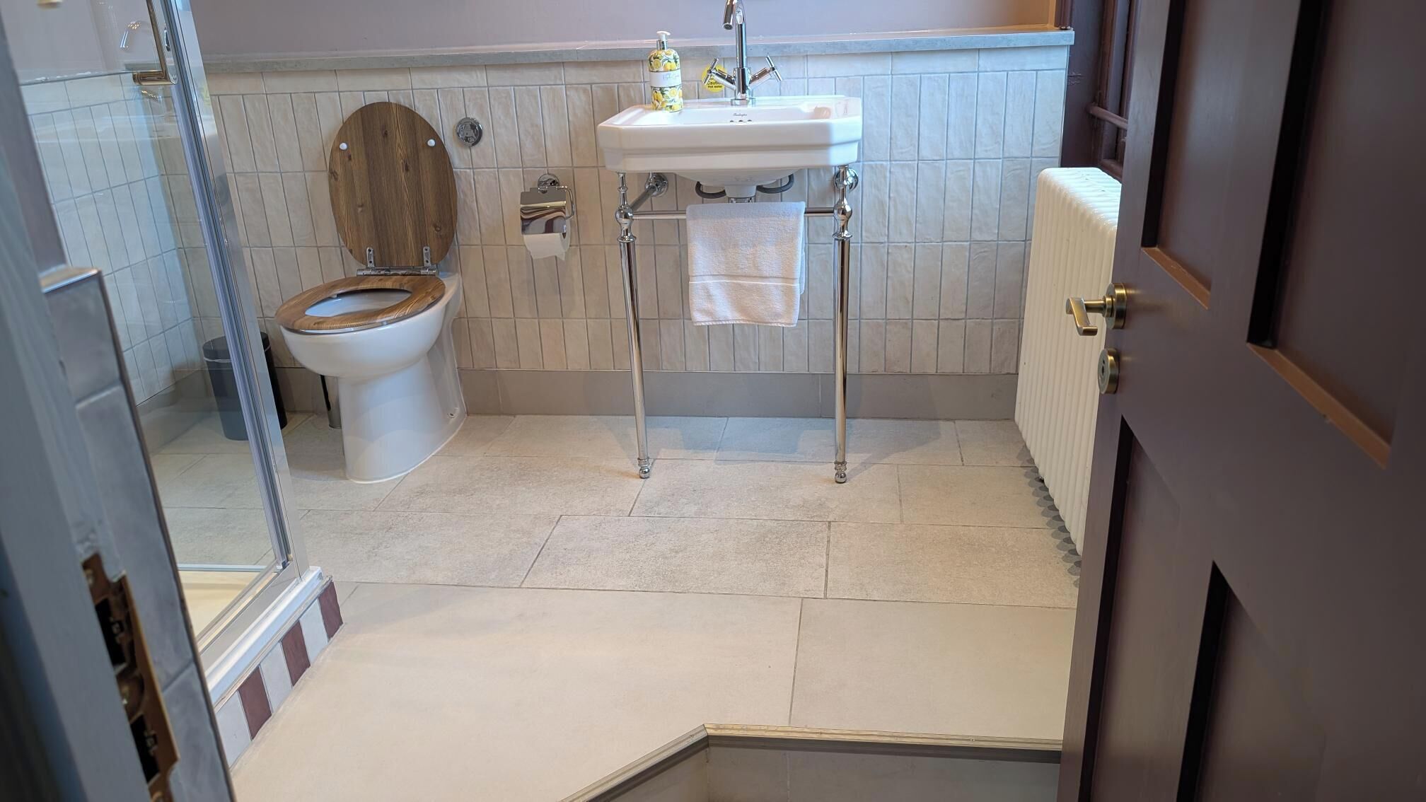 Une salle de bain équipée de toilettes, d’un lavabo et d’un porte-serviettes.