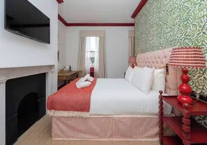 A hotel room with a bed, a television mounted on the wall, a fireplace, and a window with curtains. - New* Centrally Located room in Bath City Centre - Pass the Keys (Bath)