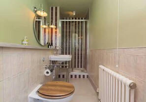 Une petite salle de bain avec des toilettes en bois, un lavabo et un espace douche.
